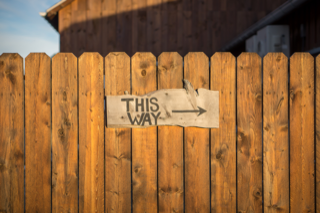 Wooden fence with sign saying 'This Way'