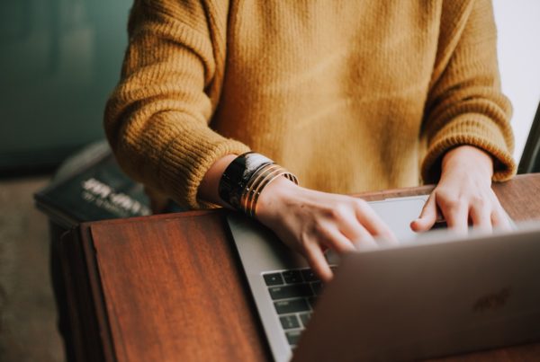Person's arms and hands working on laptop