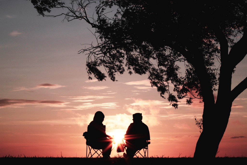 Two people talking at sunset